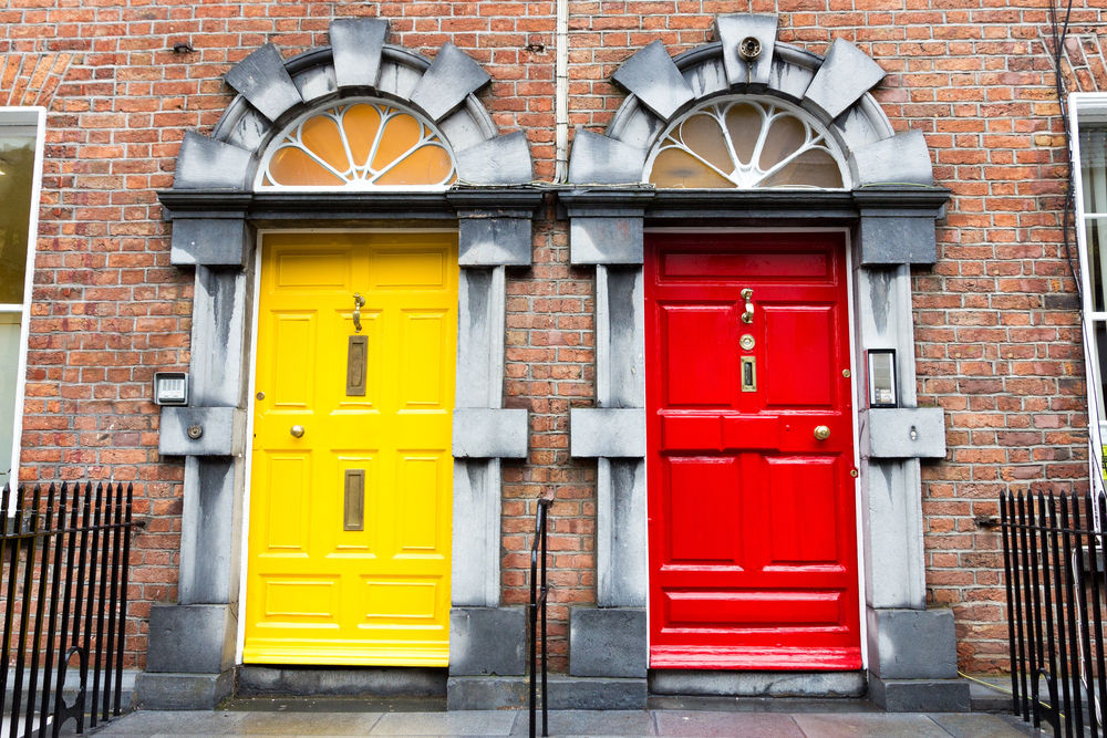 Une porte d'entrée jaune et une porte extérieure rouge