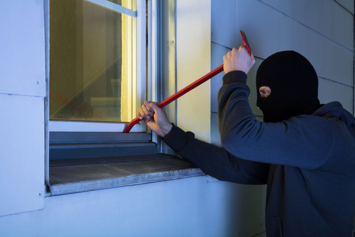 Cambrioleur tentant de passer par une fenêtre